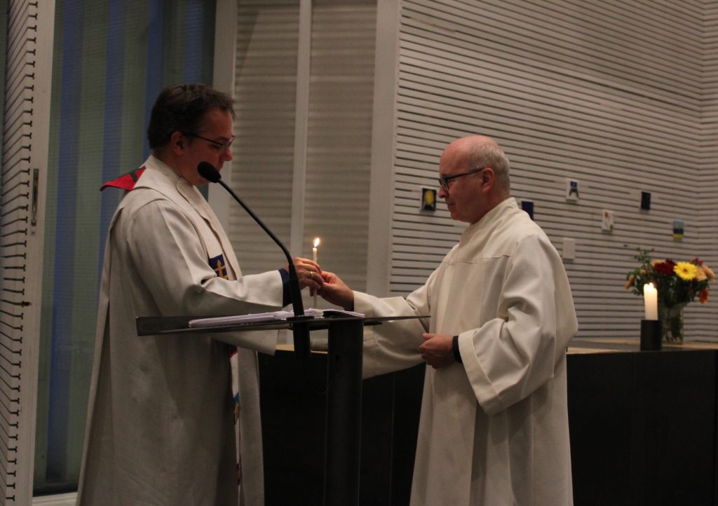 Impressionen der 1. Münchner Hospiz- und Palliativwoche im Oktober 2024. Zwei Männer in Kostümen halten eine Kerze.